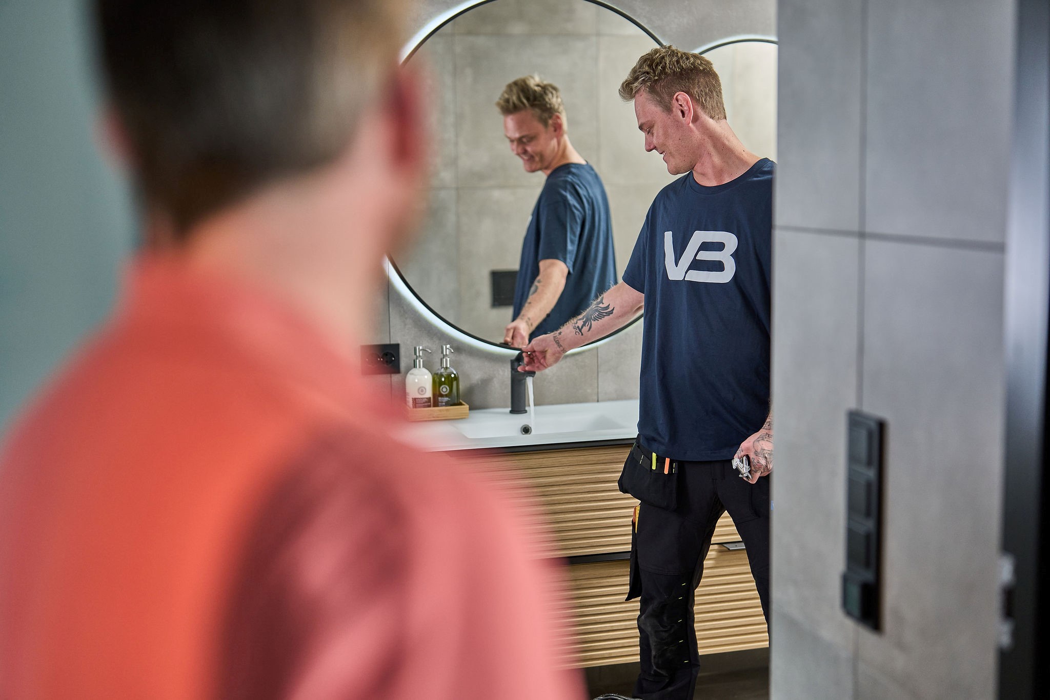 VB-rørlegger sjekker at vann kommer fra kranen som er installert på et nytt bad.